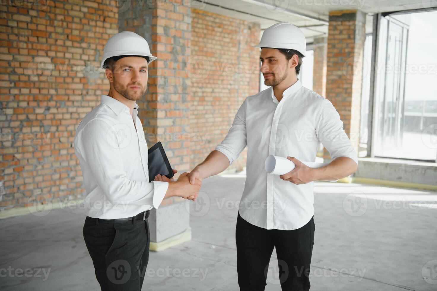 Two Specialists Inspect Commercial, Industrial Building Construction Site. Real Estate Project with Civil Engineer photo