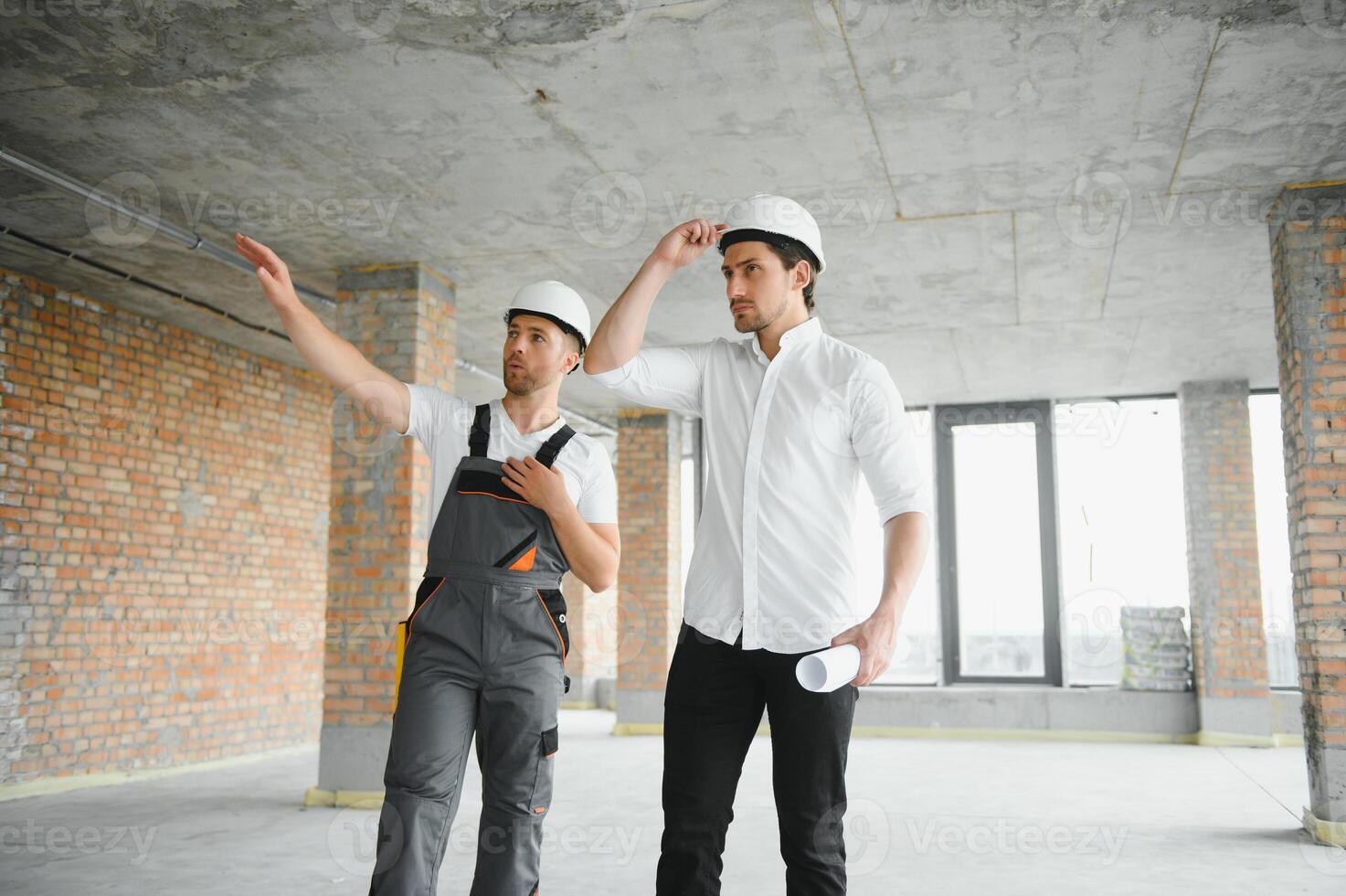 Male Architect Giving Instructions To His Foreman At Construction Site. photo