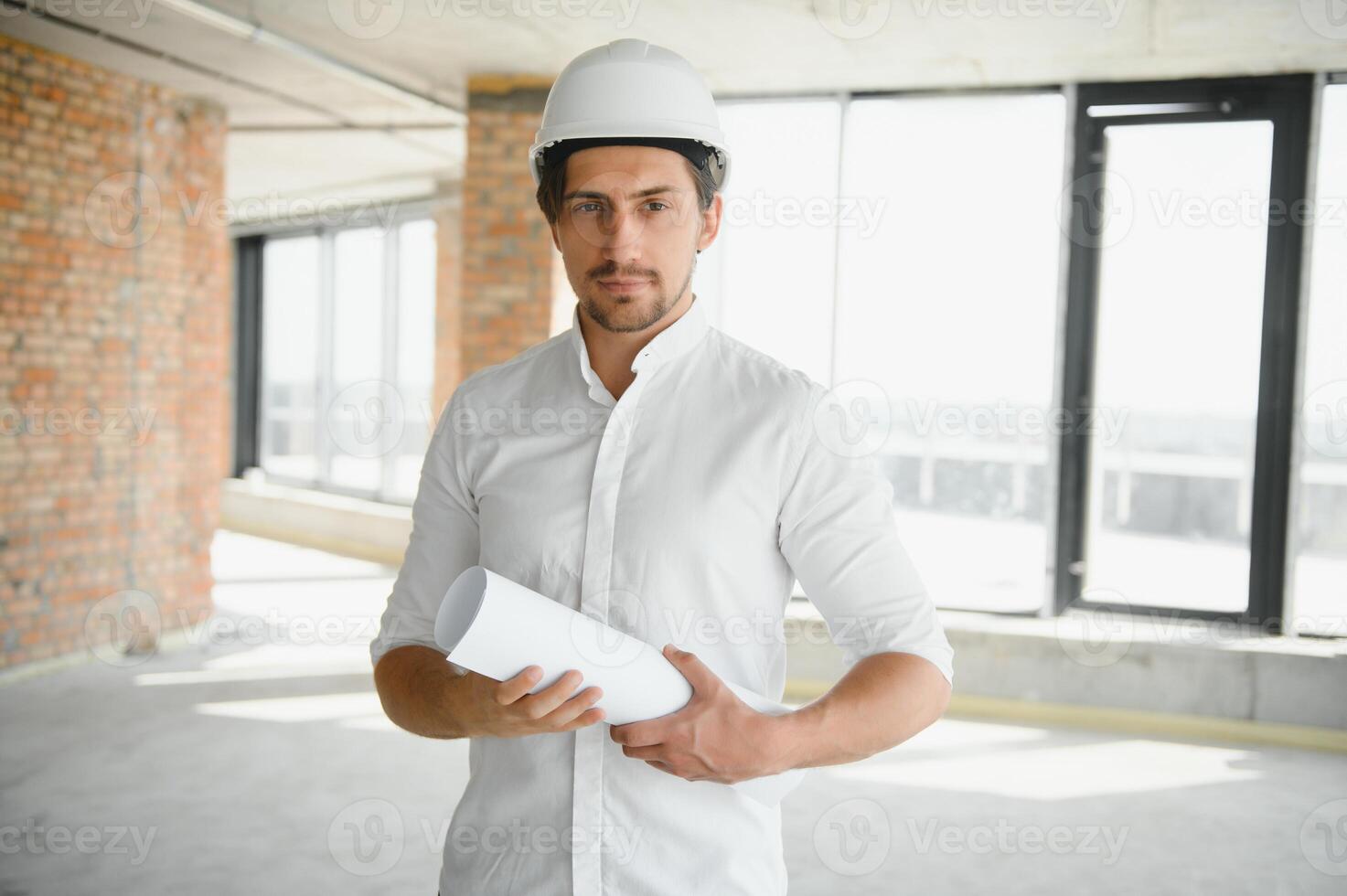 Portrait of man architect at building site. Confident construction manager wearing hardhat. Successful mature civil engineer at construction site with copy space. photo