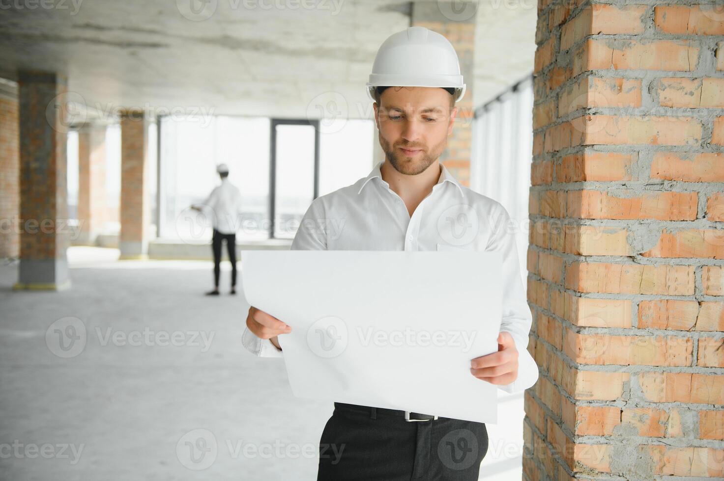 Close up engineers working on a building site holding a blueprints.Engineering and architecture concept photo