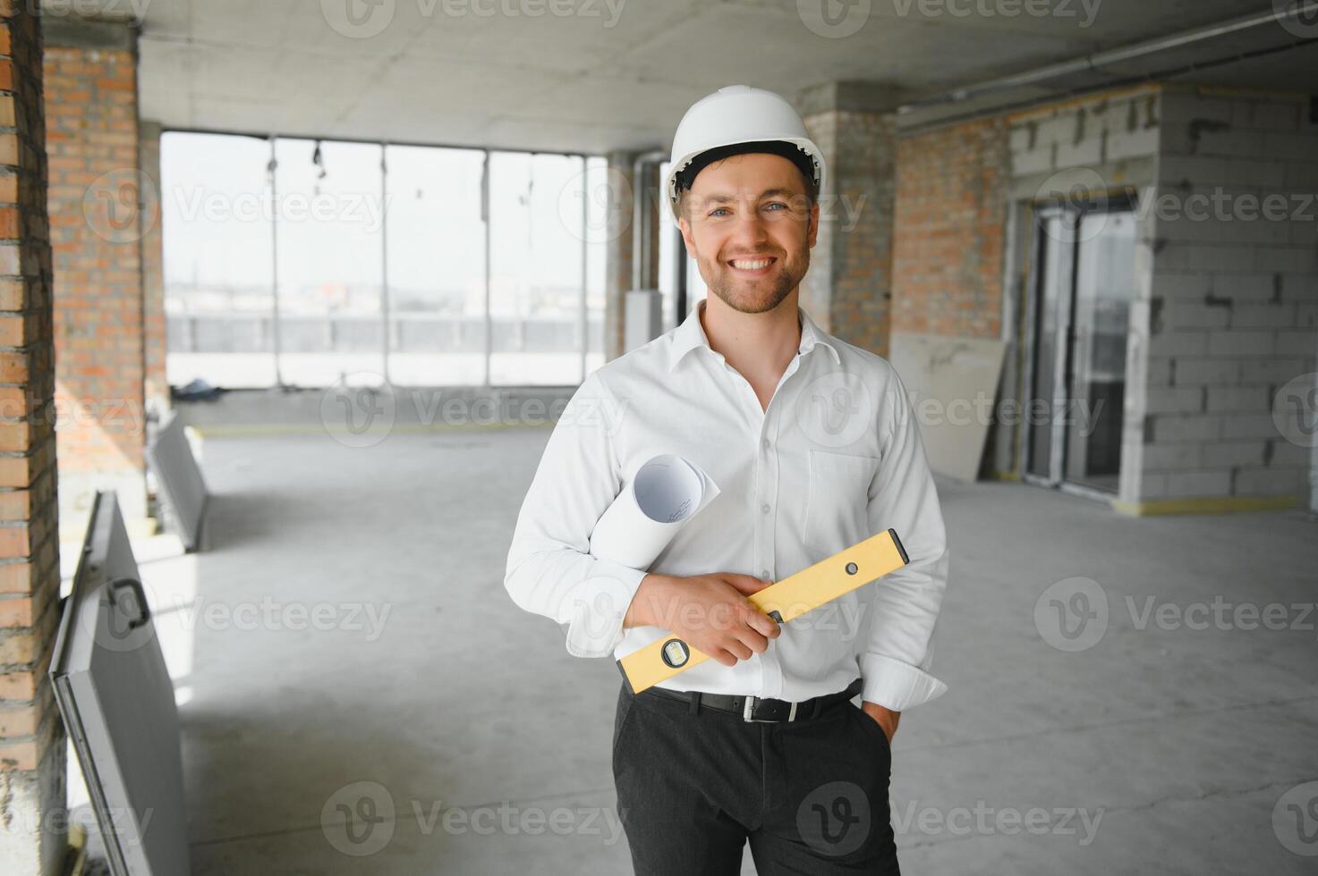 Portrait of man architect at building site. Confident construction manager wearing hardhat. Successful mature civil engineer at construction site with copy space. photo