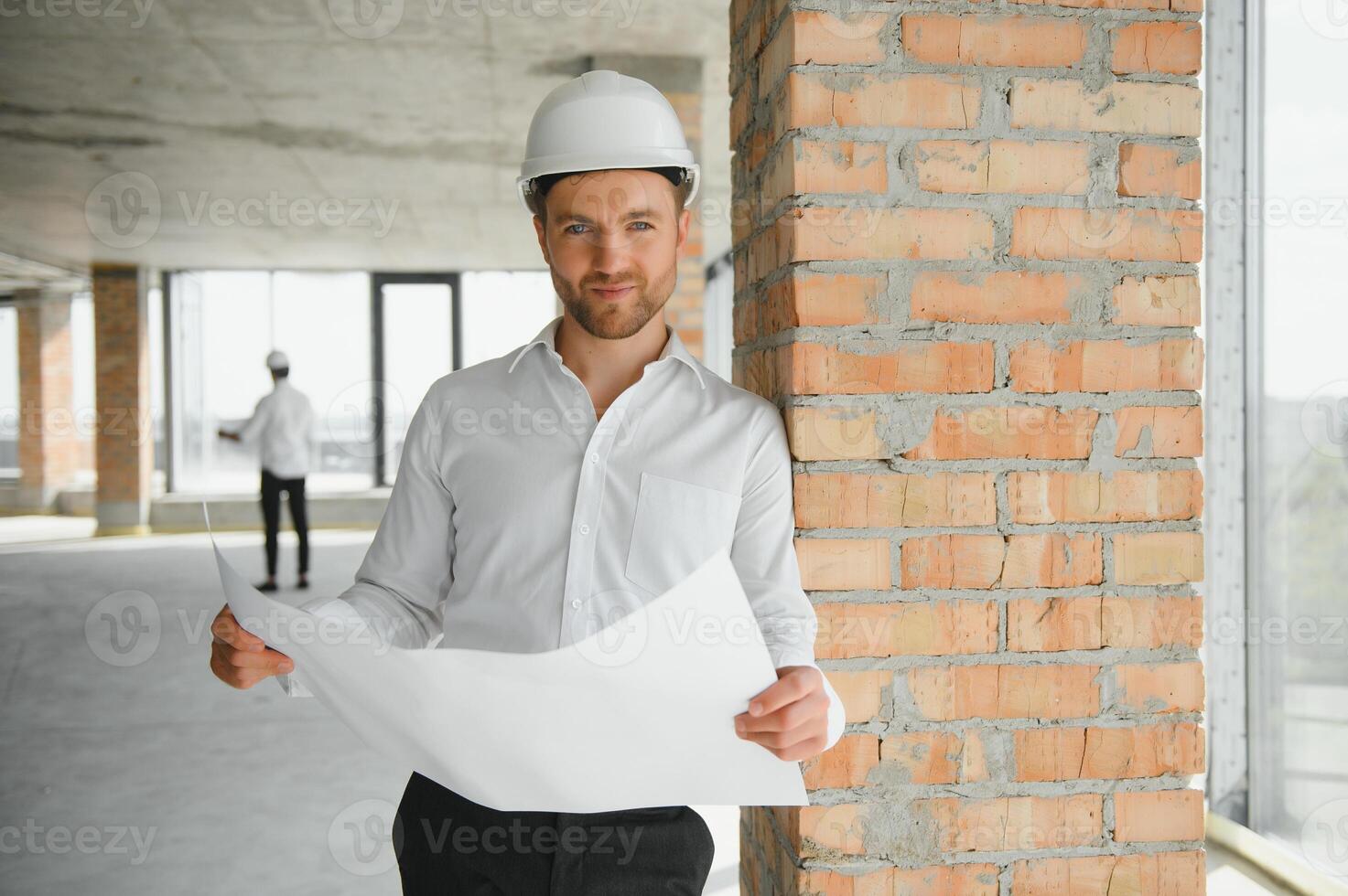 Portrait of man architect at building site. Confident construction manager wearing hardhat. Successful mature civil engineer at construction site with copy space. photo