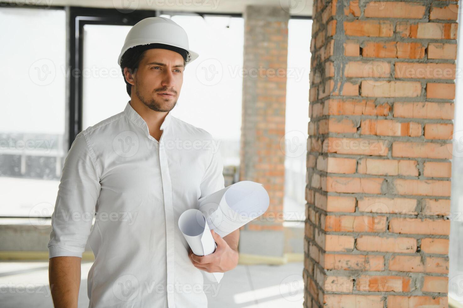 Portrait of an architect builder studying layout plan of the rooms, serious civil engineer working with documents on construction site, building and home renovation, professional foreman at work. photo