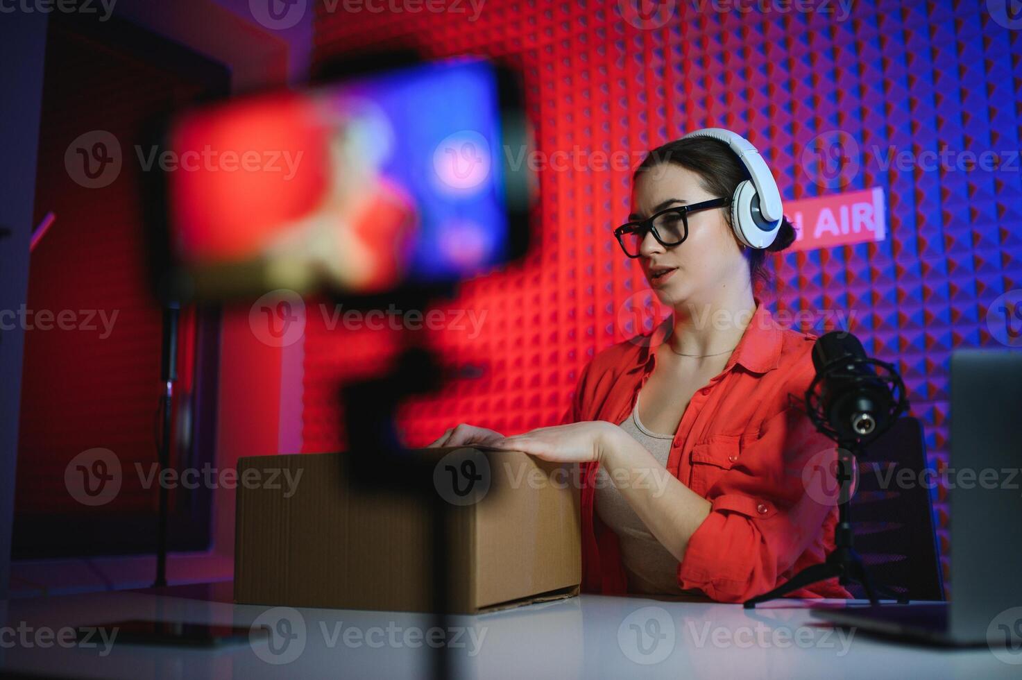 A young blogger girl records a and unpacks a box with goods from an online store photo