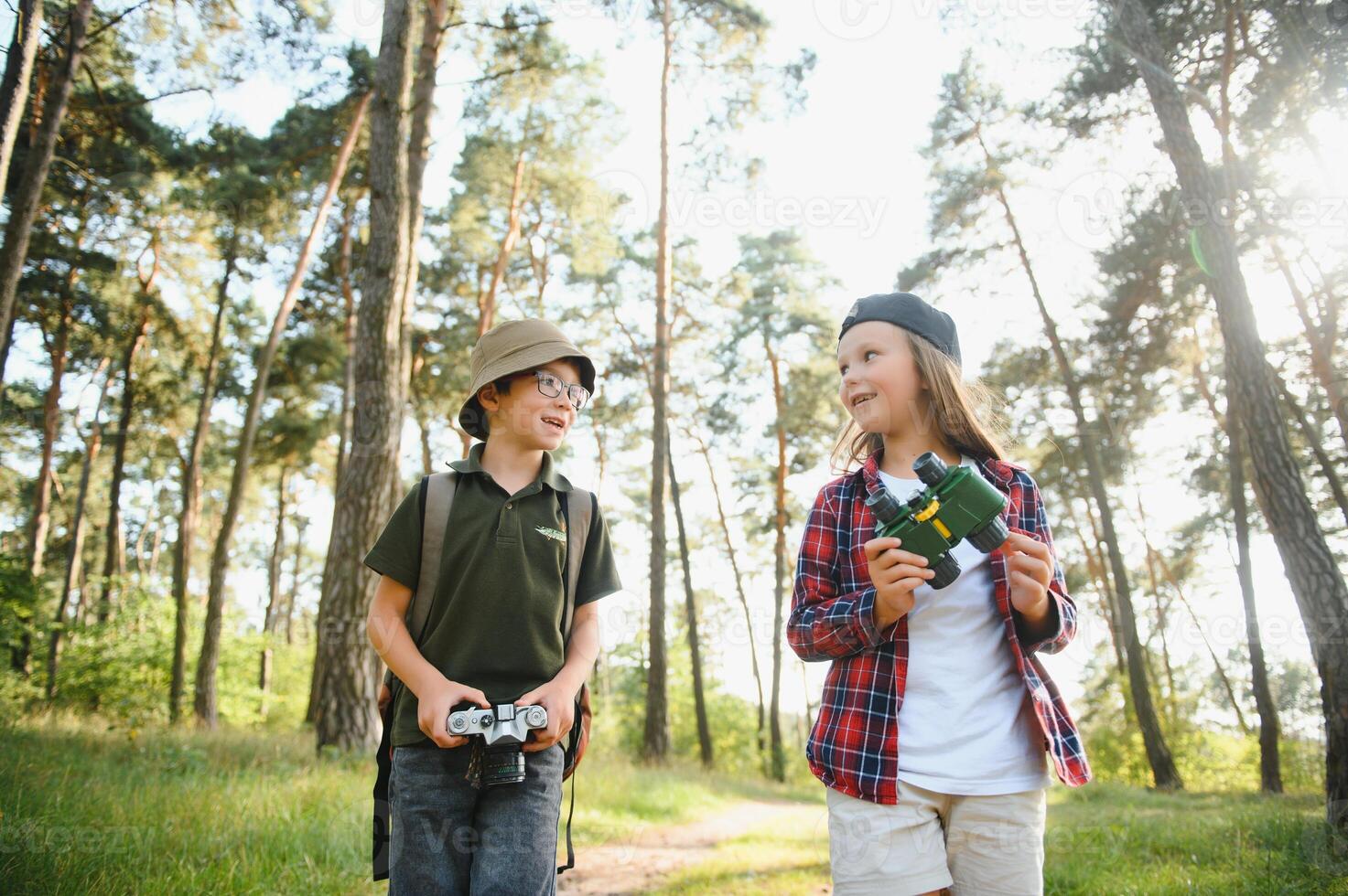 Little boy and girl go hiking on a forest road photo