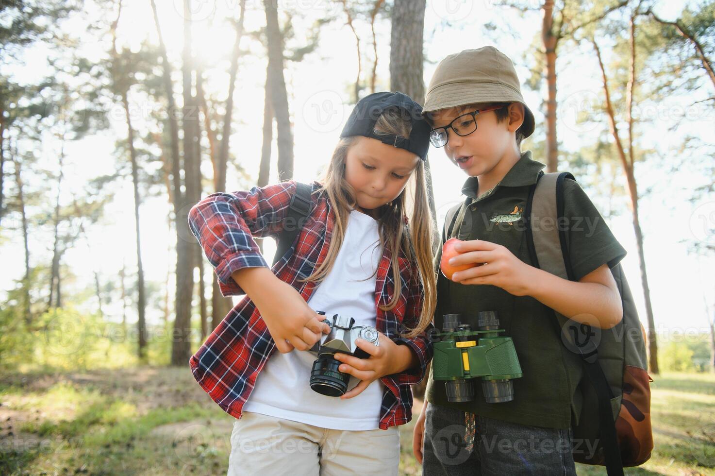 boy and girl go hiking with backpacks on forest road bright sunny day photo