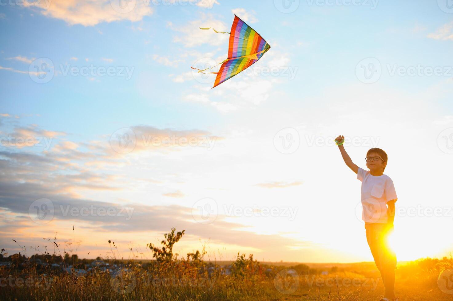 Children launch a kite in the field at sunset. photo