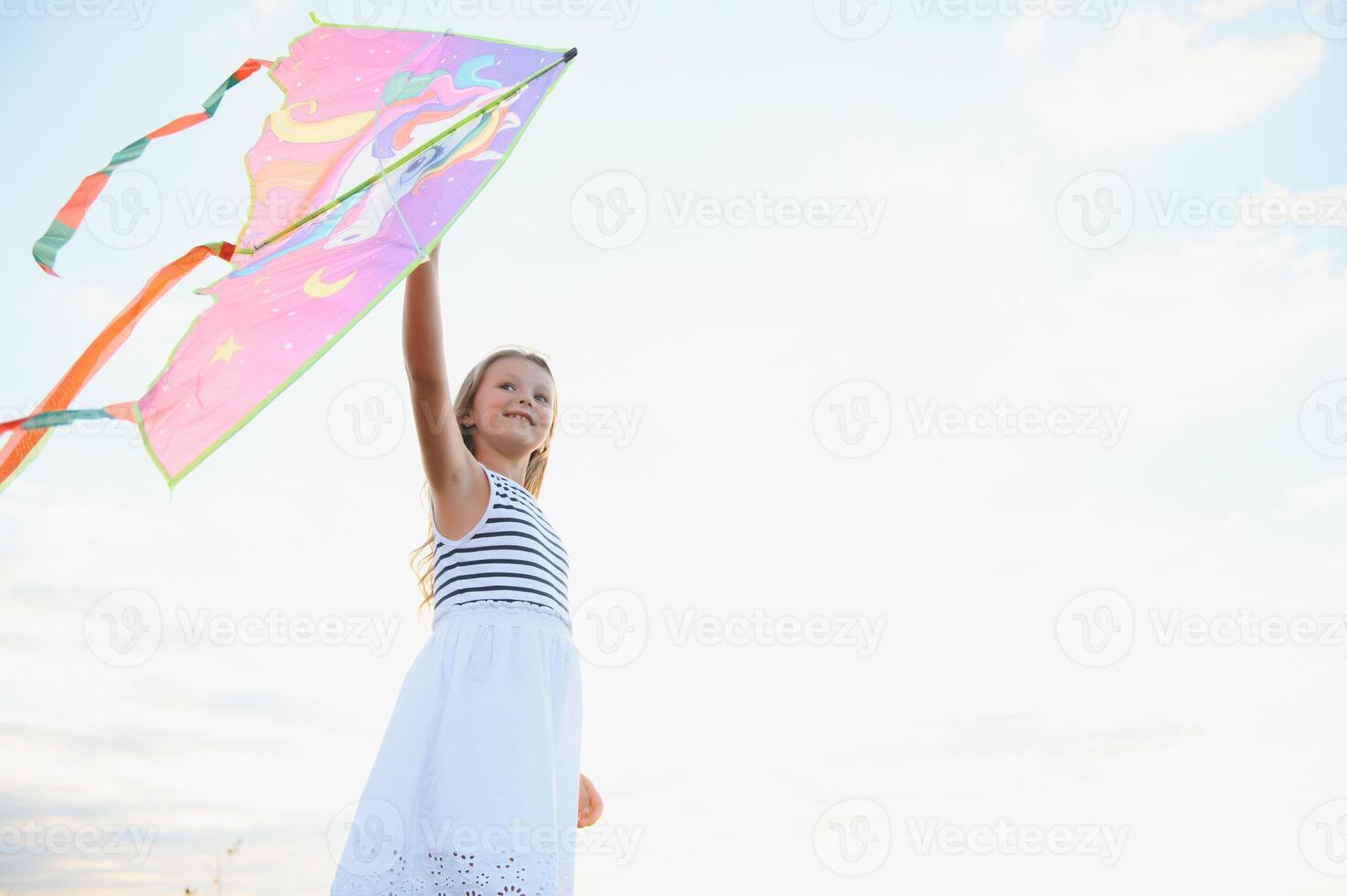 one happy little girl running on field with kite. photo