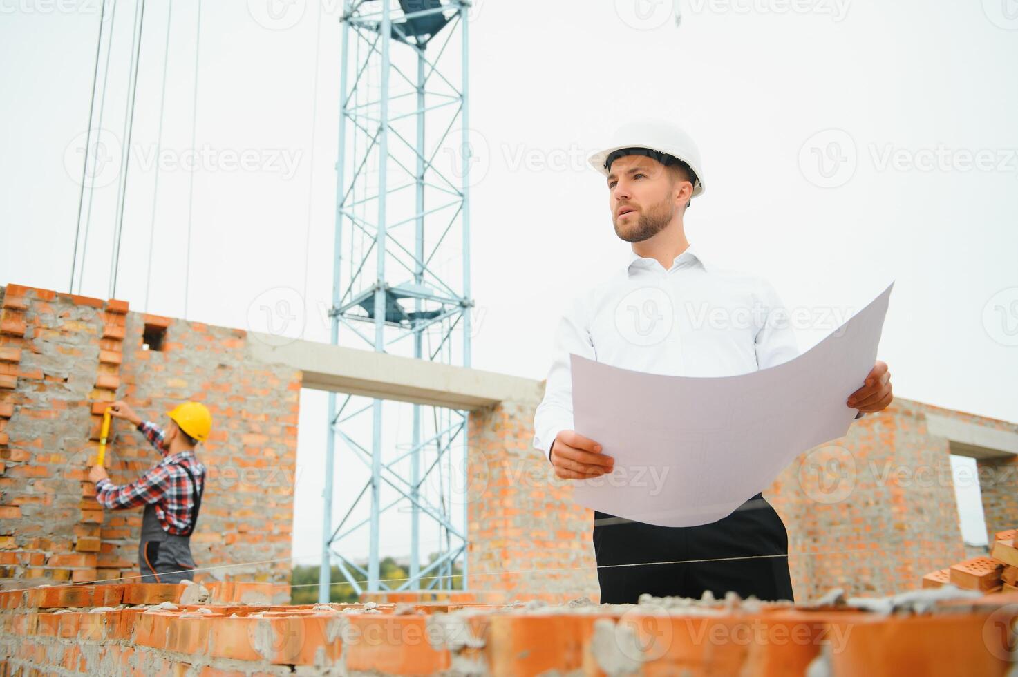 Architect at a construction site with blueprints. photo