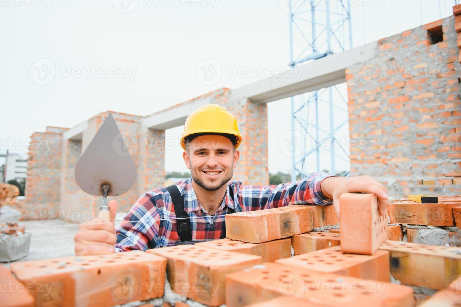 Busy with brick wall. Construction worker in uniform and safety equipment have job on building. photo