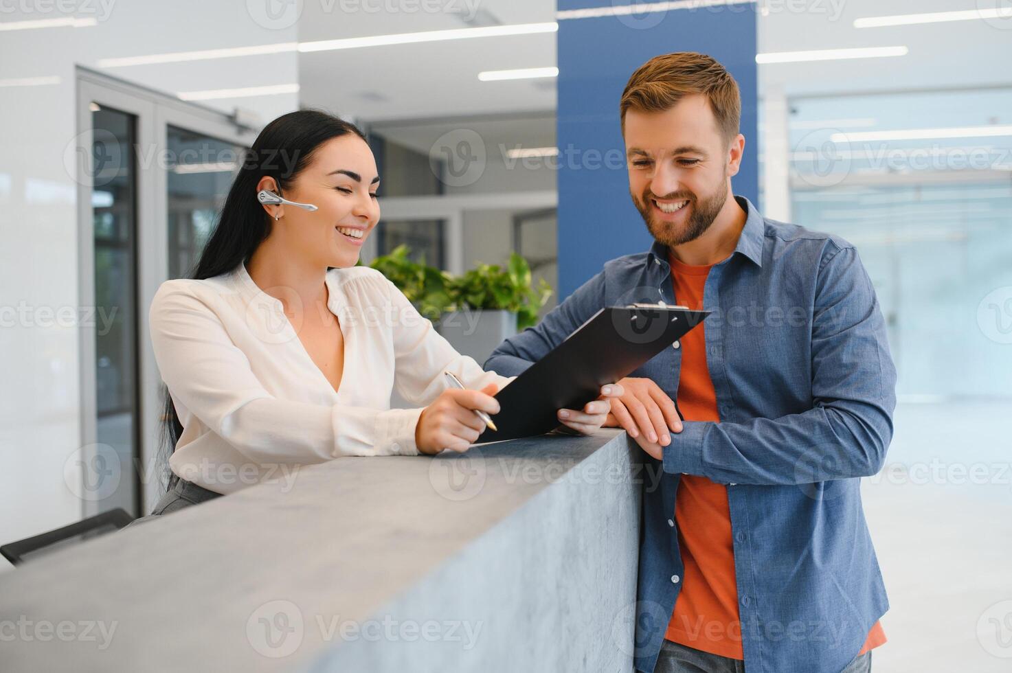 Nice friendly woman talking to the client while standing at the reception. photo