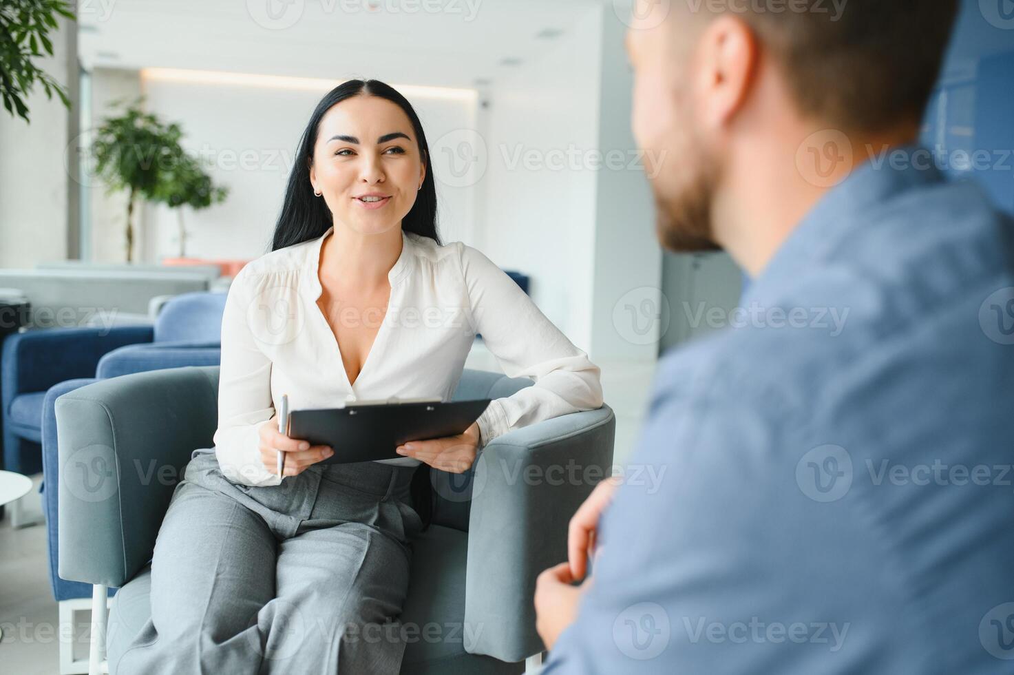 Business concept. Young dark-haired woman sitting in front of mature cheerful office manager on job interview, having relaxing talk about her experience and study degree. photo
