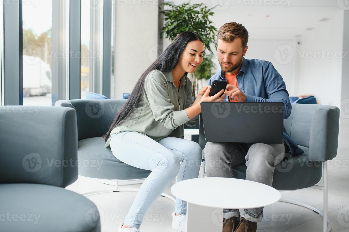 Smiling businesspeople work collaborate on computer, brainstorm over company startup at office meeting. Motivated diverse colleagues look at laptop screen discuss business project ideas together photo