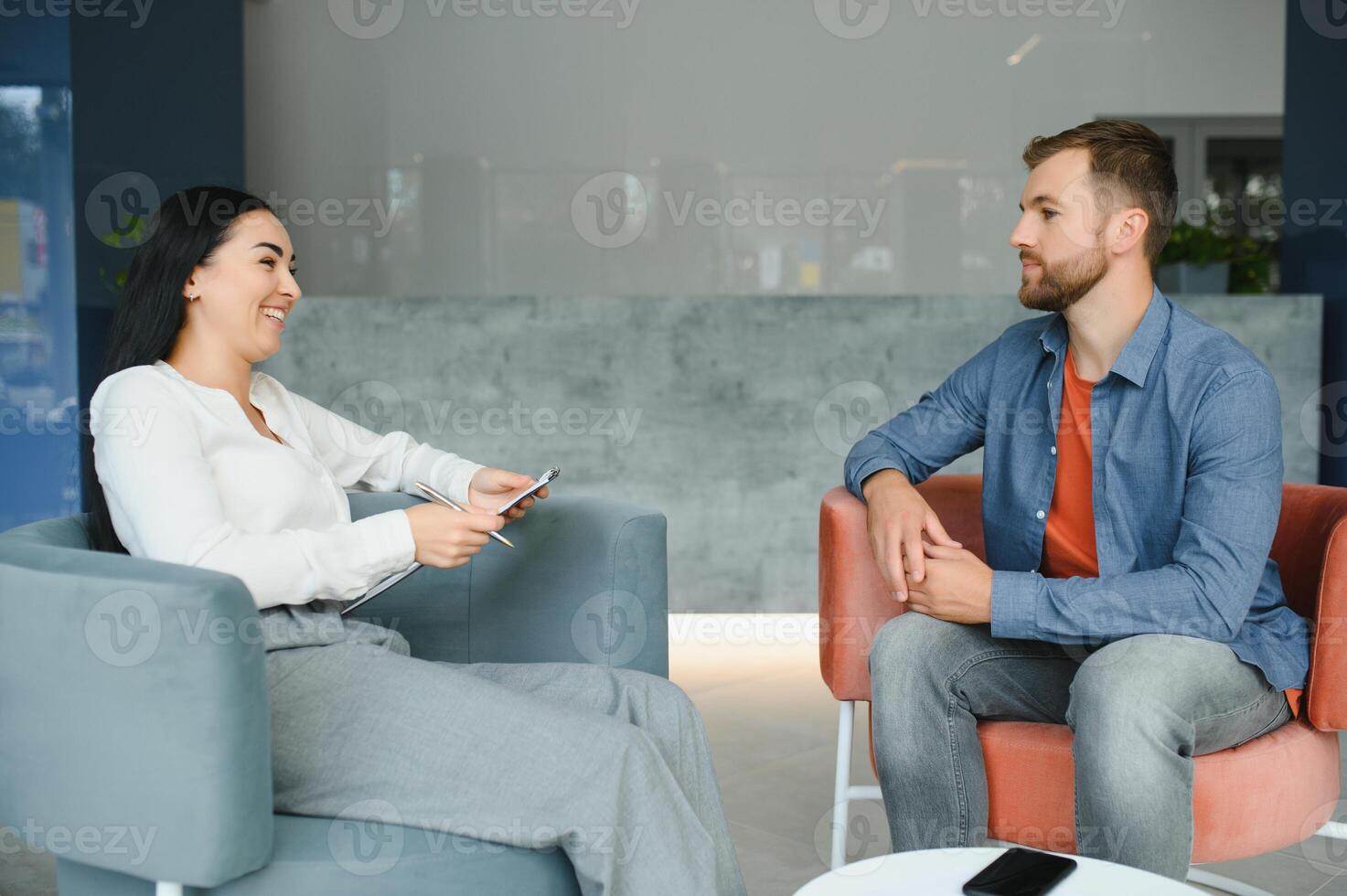 Business concept. Young dark-haired woman sitting in front of mature cheerful office manager on job interview, having relaxing talk about her experience and study degree. photo