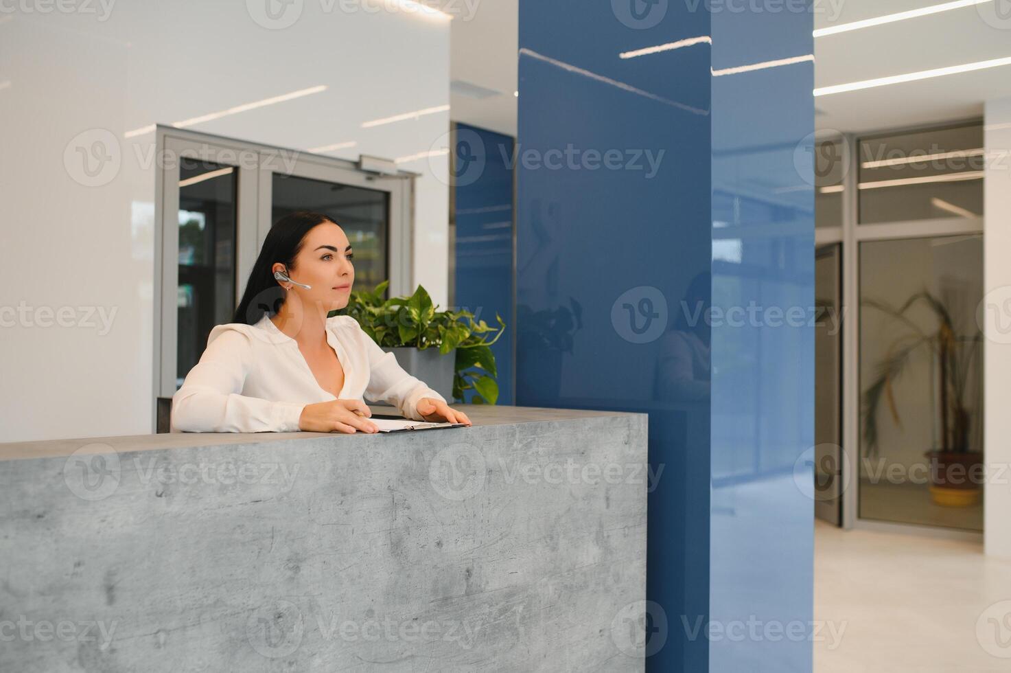 Nice friendly woman talking to the client while standing at the reception. photo