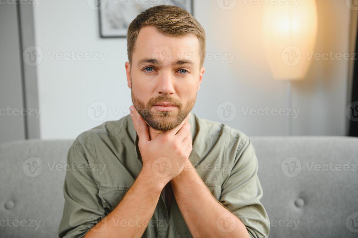 Sore throat. Dark-haired young man having a sore throat. photo