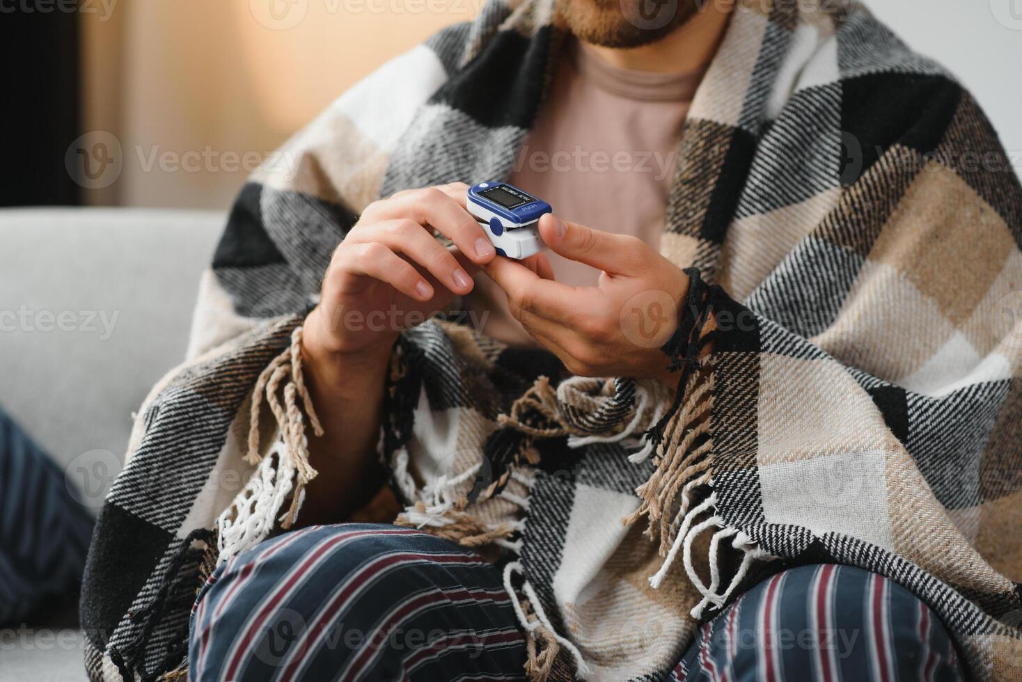 Close up of oximeter on hand of ill person resting while measuring oxygen saturation and pulse pressure to check virus symptoms. Sick adult using device for healthcare treatment. photo