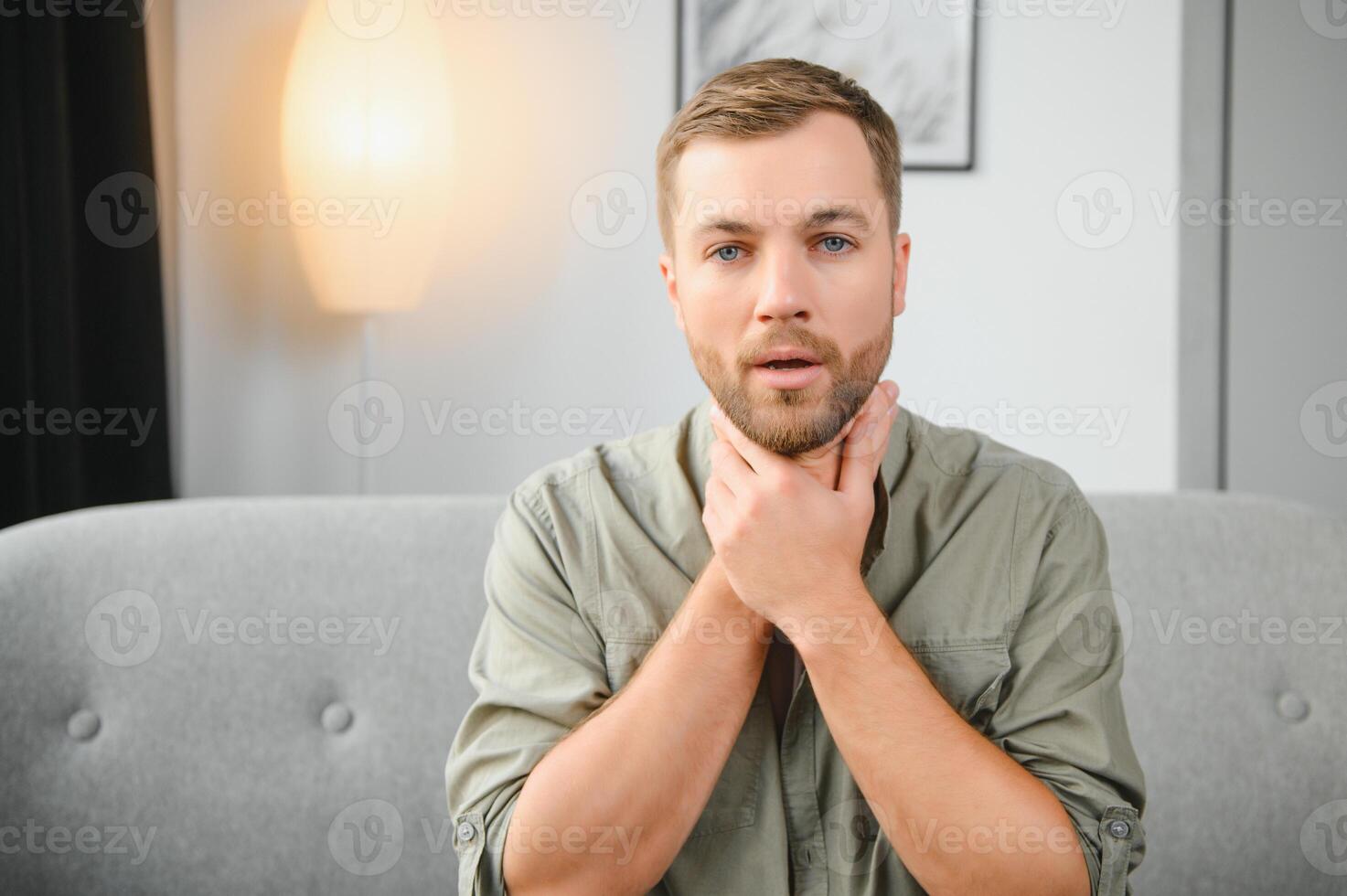 Sore throat. Dark-haired young man having a sore throat. photo