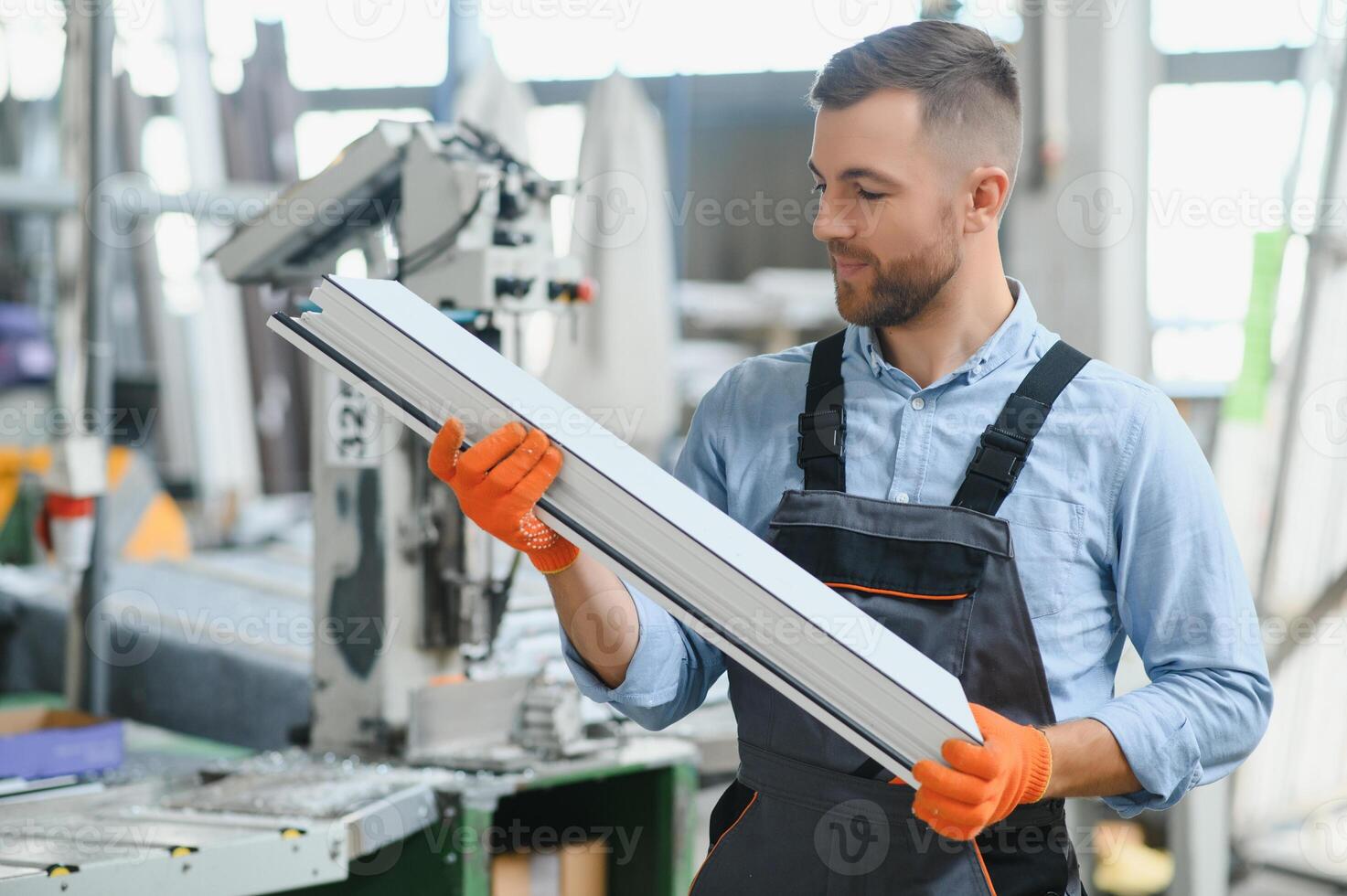 Factory for aluminum and PVC windows and doors production. Manual worker assembling PVC windows and doors photo
