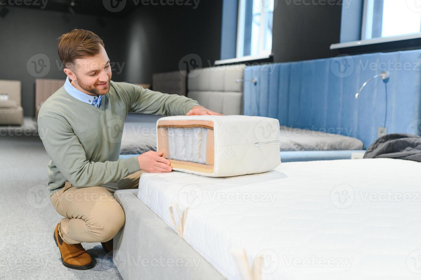 A handsome young man chooses furniture in a store photo