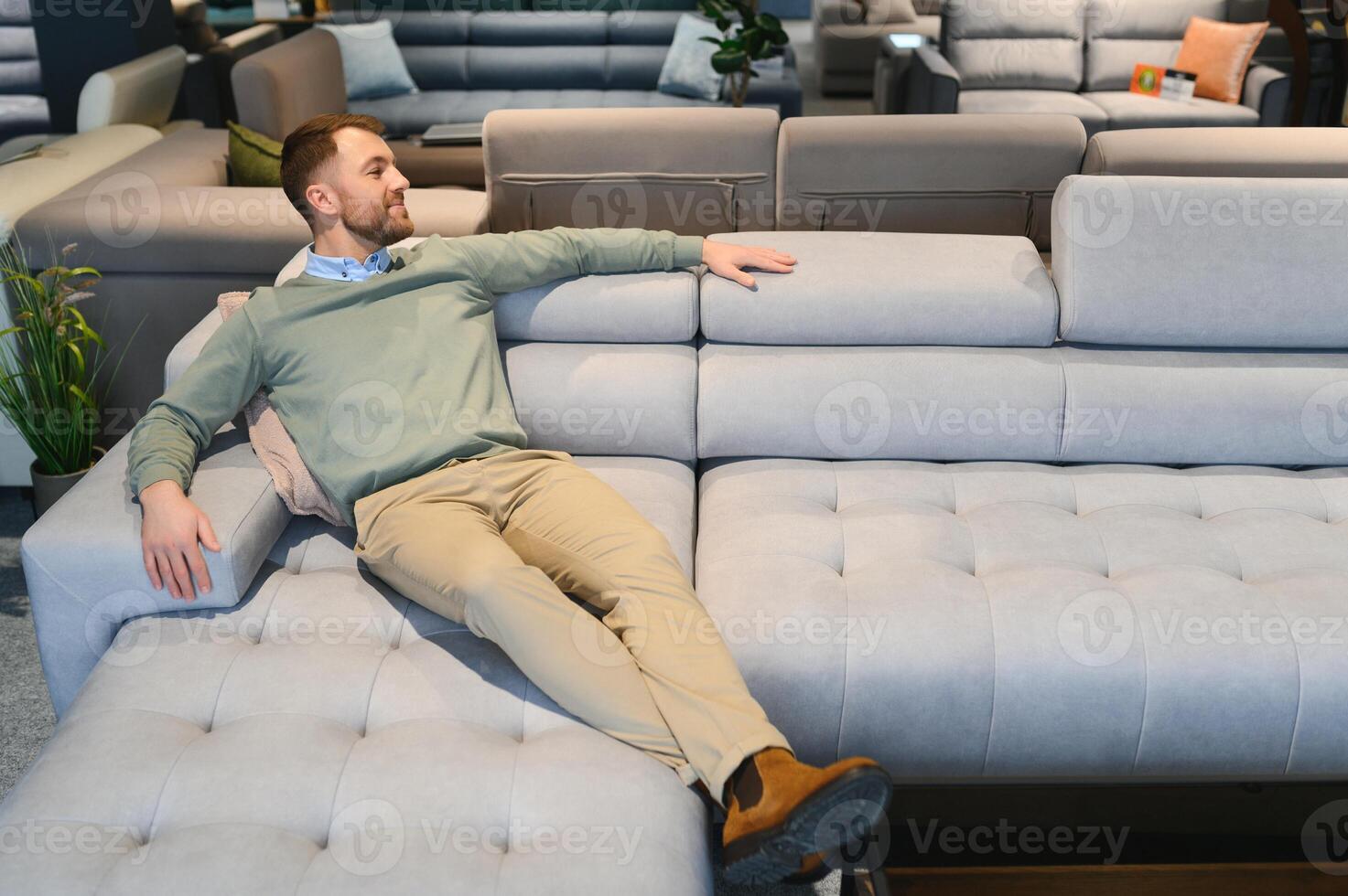 A handsome young man chooses furniture in a store photo