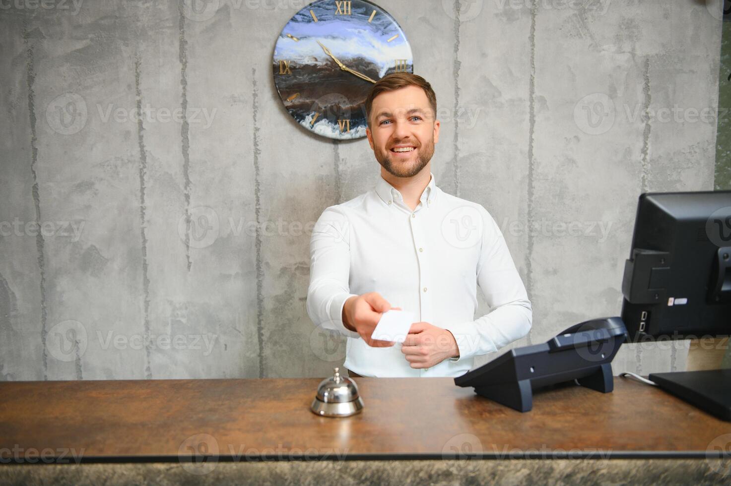 Portrait of a young male receptionist in a hotel lobby wearing a white shirt photo