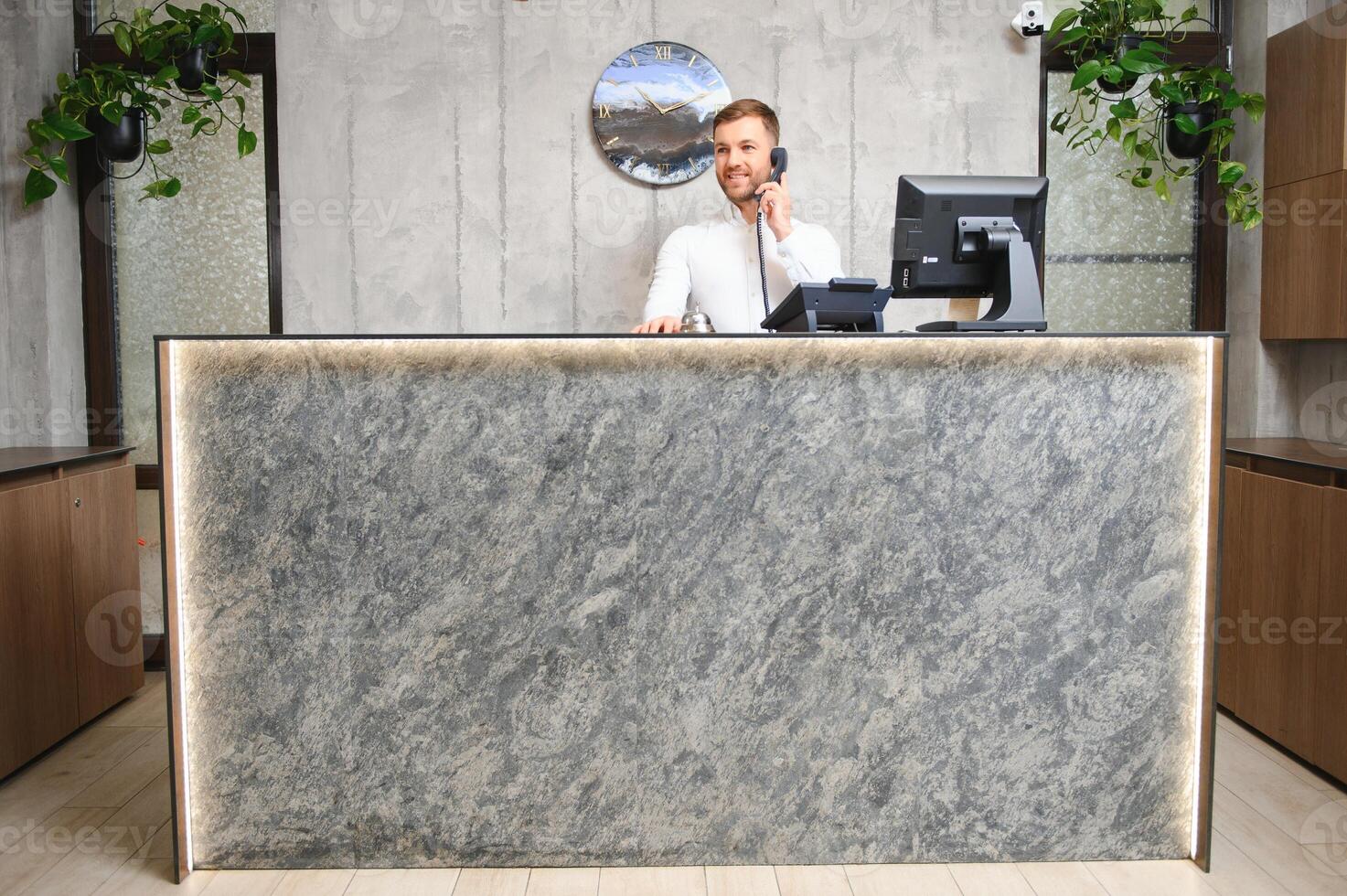 Portrait of receptionist at desk in lobby, hotel photo