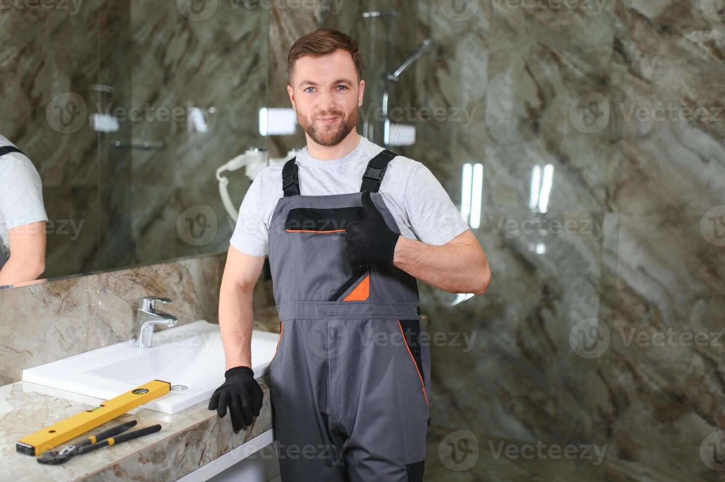 A man is setting the washbasin over the cabinet in the bathroom photo