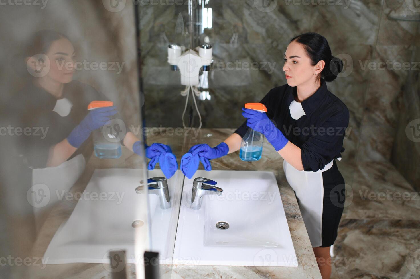 Maid woman cleans bathroom in hotel photo