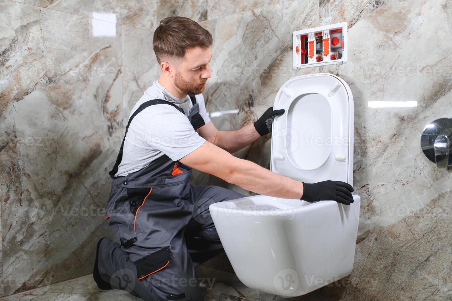 Plumber installing toilet in restroom photo