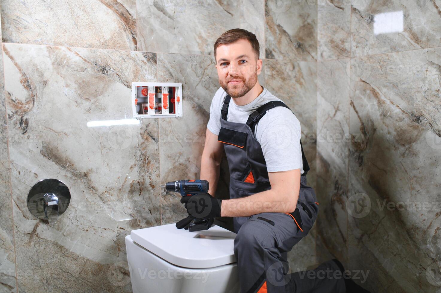 Plumber installing toilet in restroom photo