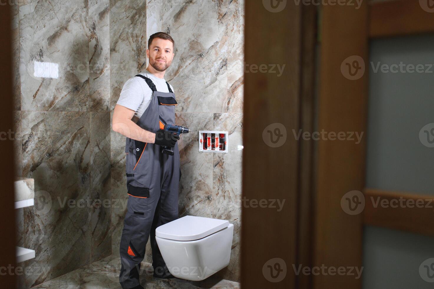 Plumber installing toilet in restroom photo