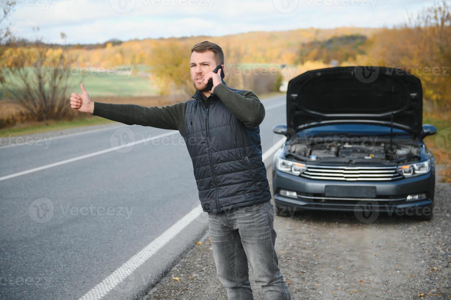A man calls a phone number to talk to a mechanic. The car broke down on the roadside. The concept for fix, help, problem, repair. blurred background. photo