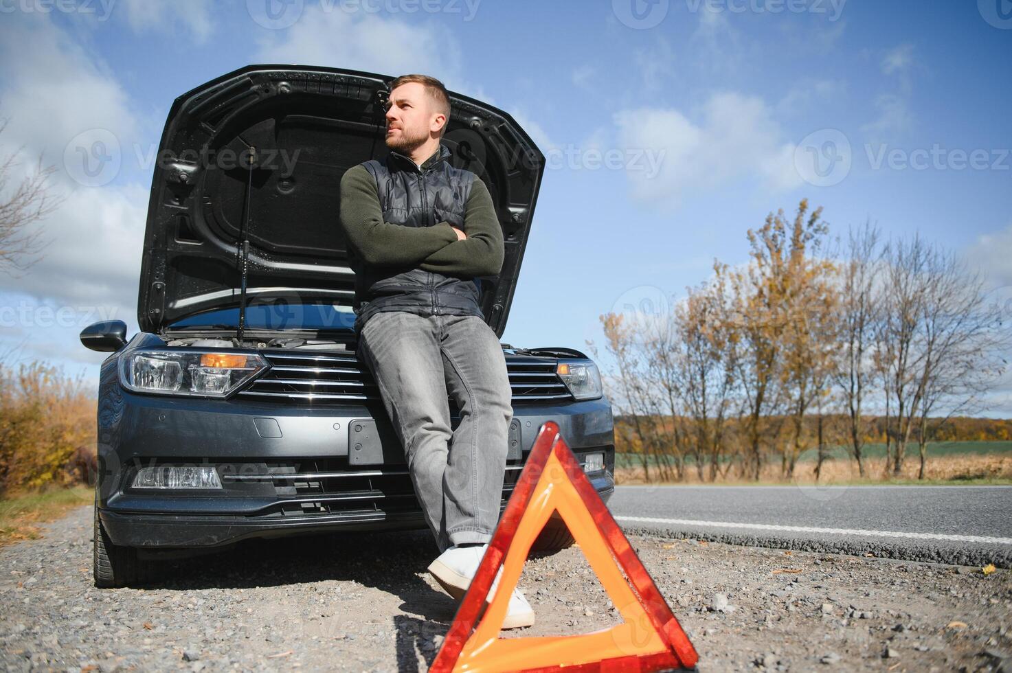 A young man with a black car that broke down on the road,copy space. photo