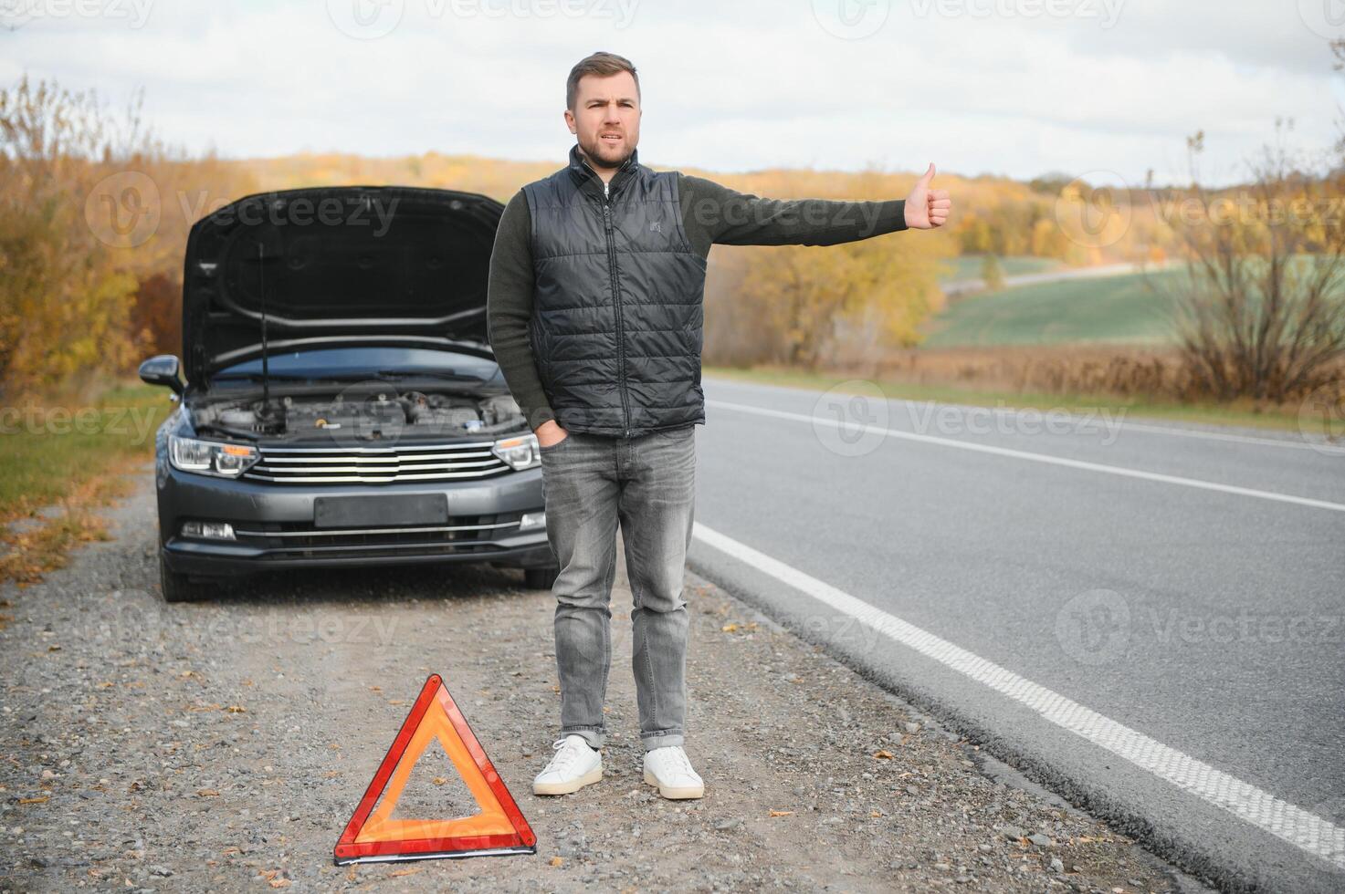 Man with broken car in the middle of the road. photo