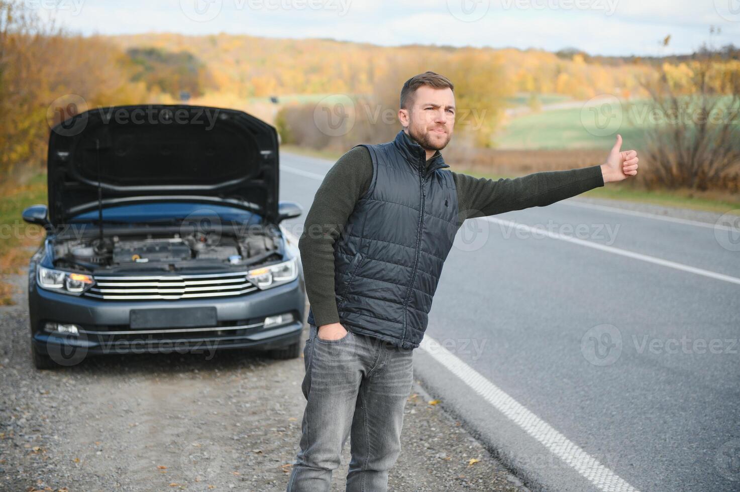 Man with broken car in the middle of the road. photo