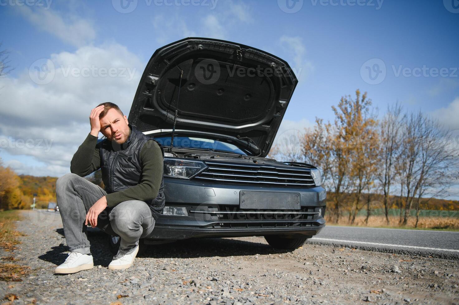 Man with broken car in the middle of the road. photo