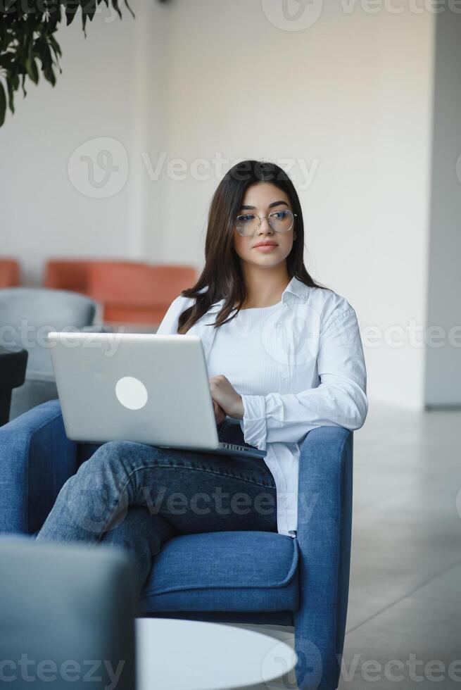 Beautiful Caucasian woman dreaming about something while sitting with portable net-book in modern cafe bar, young charming female freelancer thinking about new ideas during work on laptop computer photo