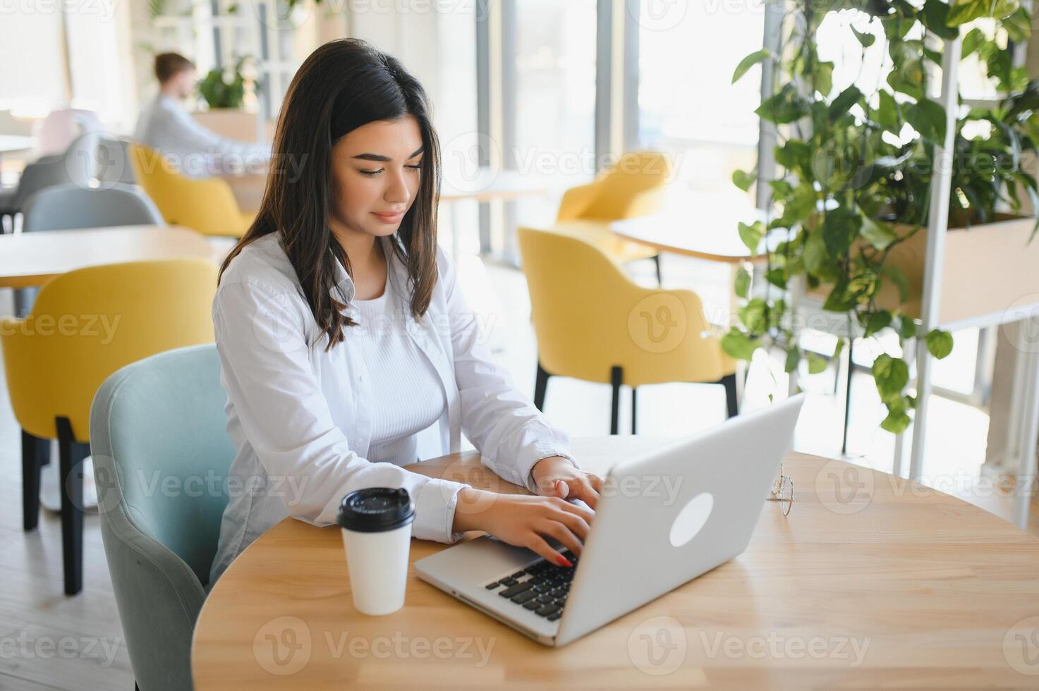 Beautiful Caucasian woman dreaming about something while sitting with portable net-book in modern cafe bar, young charming female freelancer thinking about new ideas during work on laptop computer photo