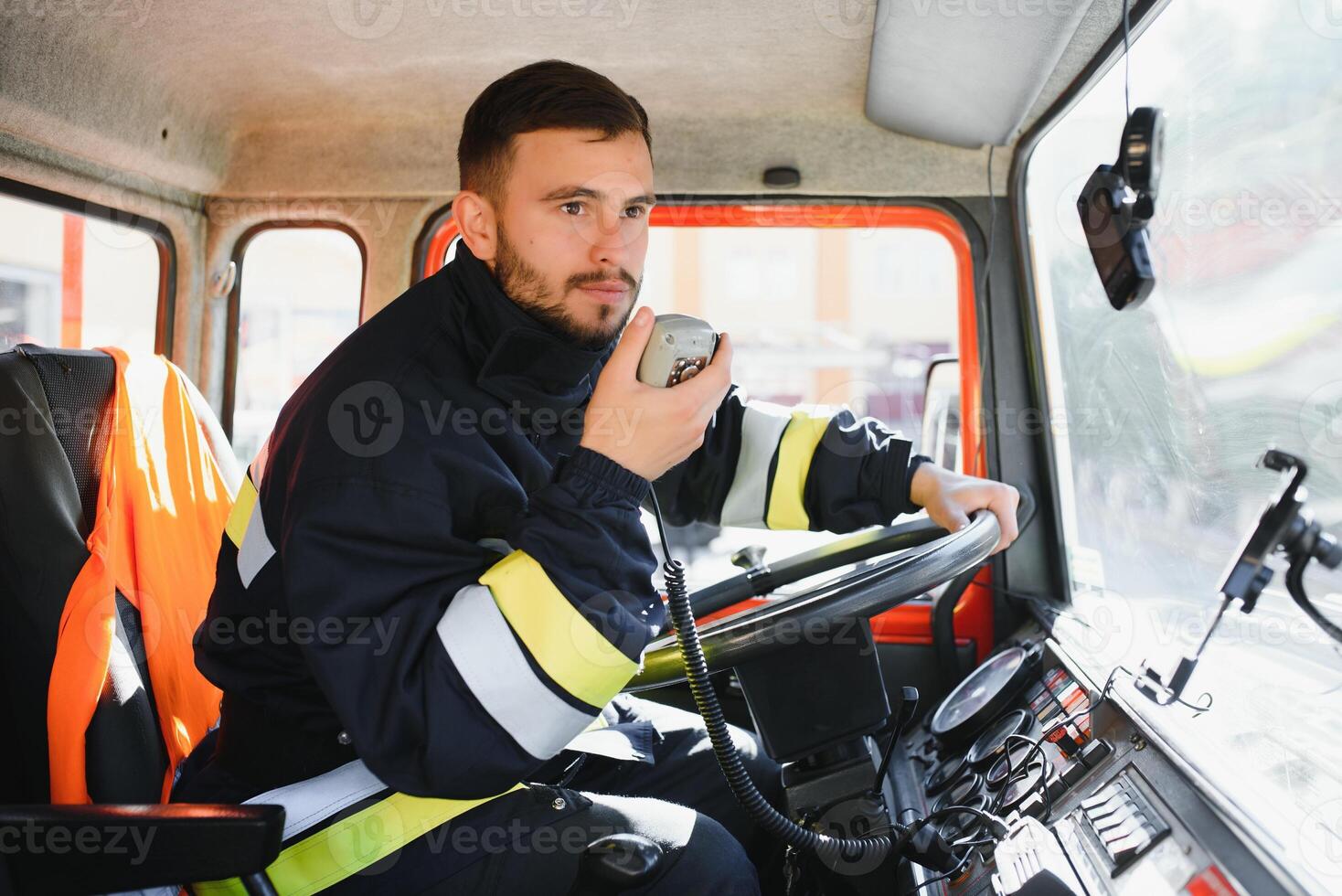 Firefighter using radio set while driving fire truck. photo