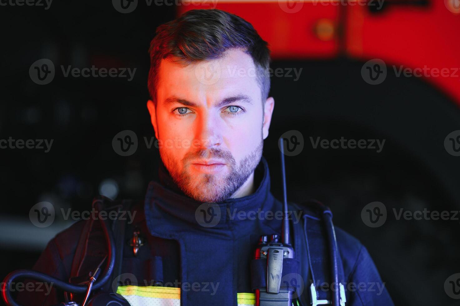 Fireman firefighter in action standing near a firetruck. Emergency safety. Protection, rescue from danger. photo