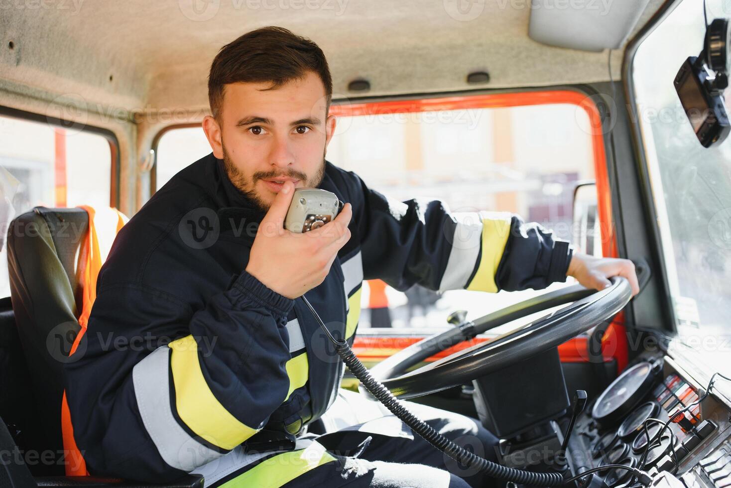 Firefighter using radio set while driving fire truck. photo