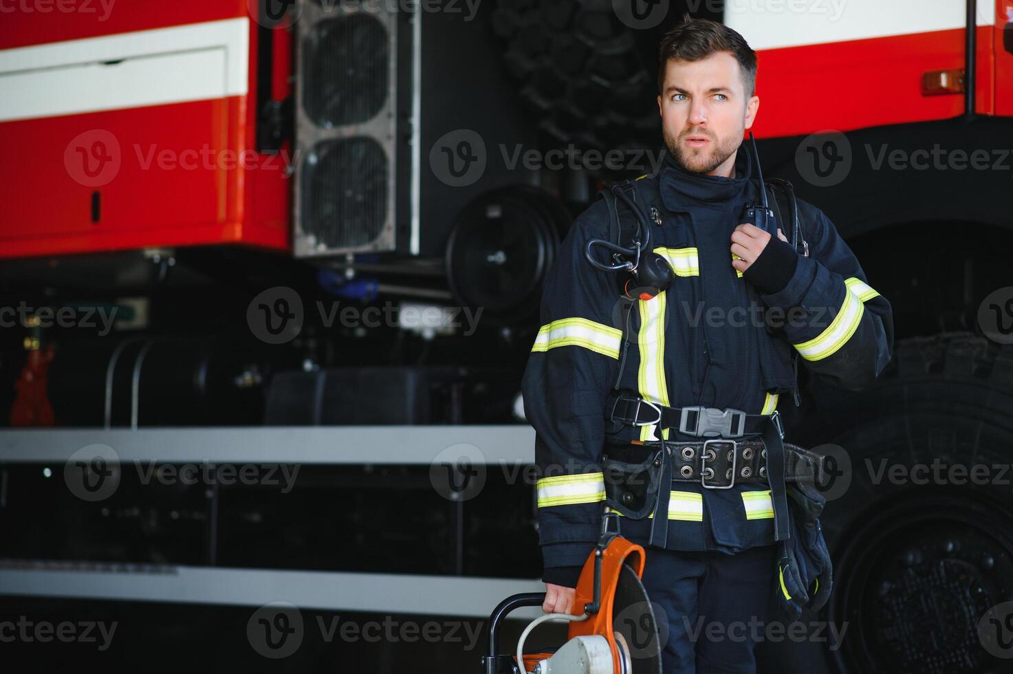 Brave young fireman wearing protective uniform. photo