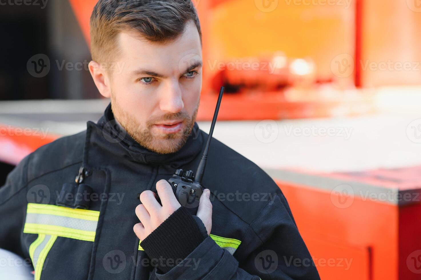 Firefighter portrait on duty. Photo fireman with gas mask and helmet near fire engine.