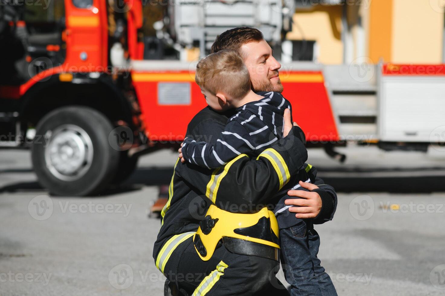 Firefighter holding child boy to save him in fire and smoke,Firemen rescue the boys from fire photo