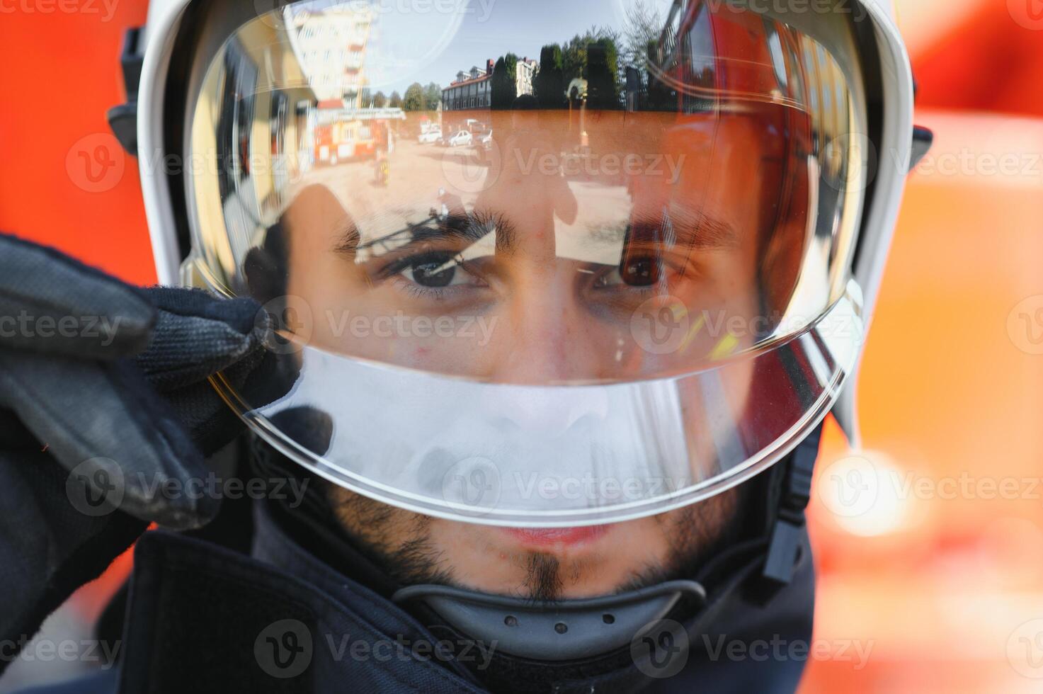 Firefighter portrait on duty. Photo fireman with gas mask and helmet near fire engine.