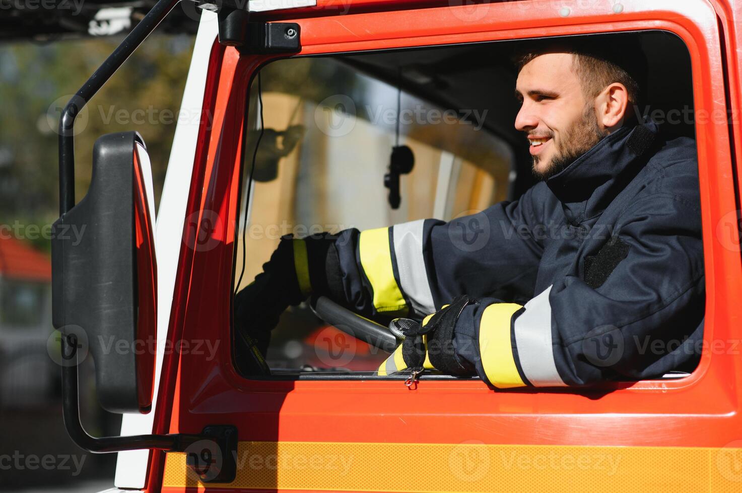 Firefighter at the wheel of an emergency vehicle drives to the scene of action and extinguishes fire. photo