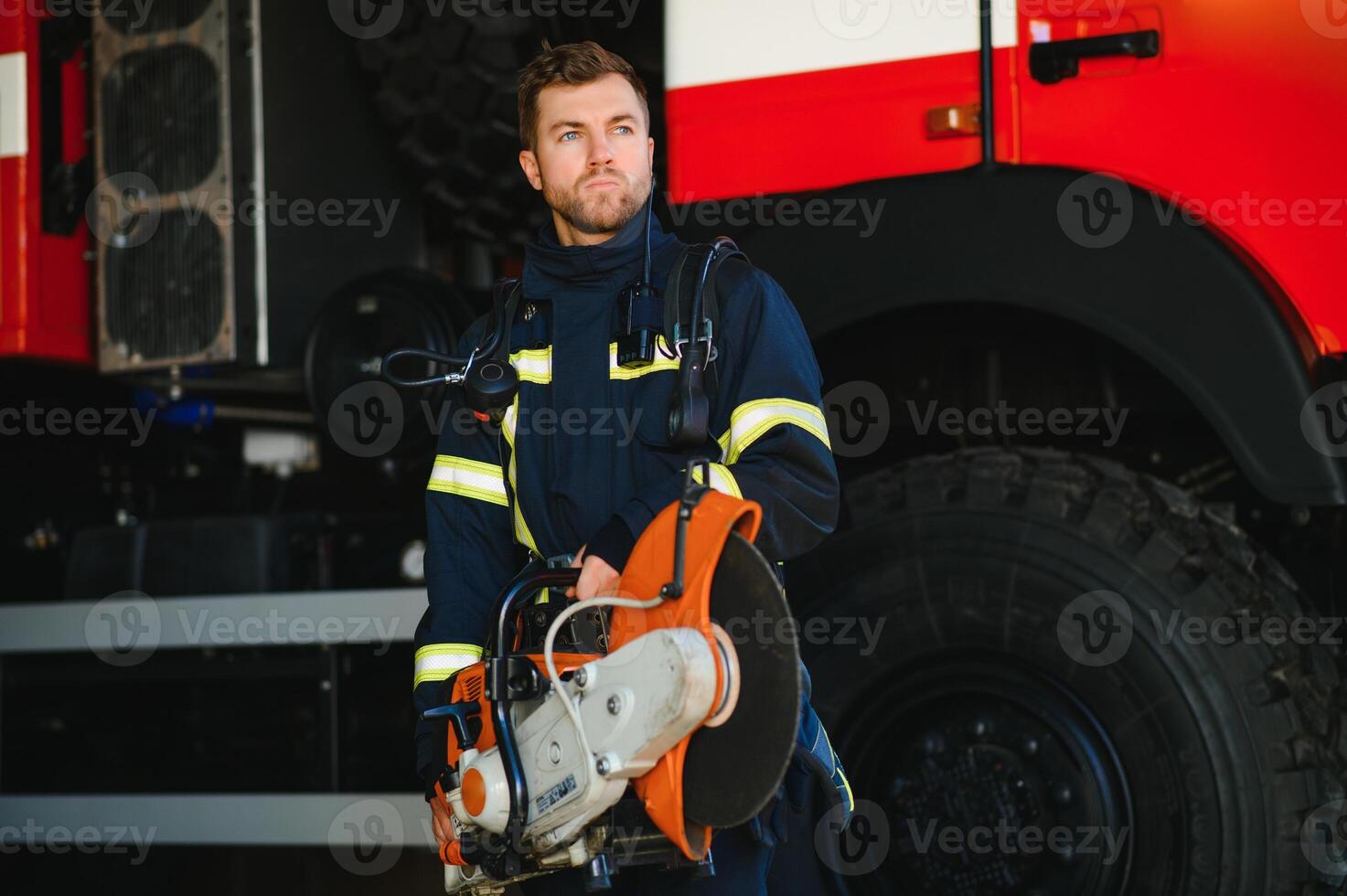 Fireman, firefighter in action standing near a firetruck. Emergency safety. Protection, rescue from danger. photo