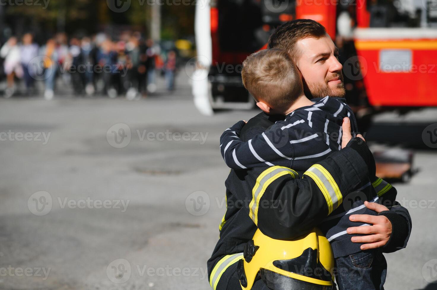 Firefighter holding child boy to save him in fire and smoke,Firemen rescue the boys from fire photo
