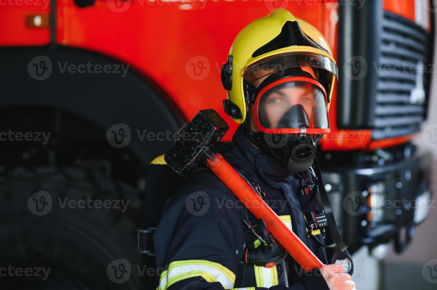 Fireman, firefighter in action standing near a firetruck. Emergency safety. Protection, rescue from danger. photo